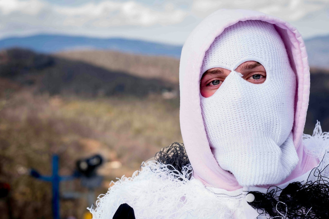 a person wearing a white mask with a pink hood